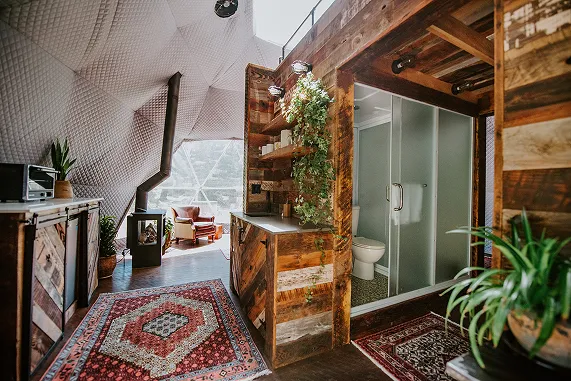 Dome interior with reclaimed-wood bathroom at Akasha Farm